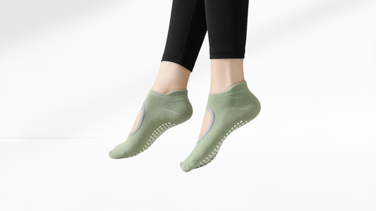 Green slip-resistant grip socks worn by a person on a white background
