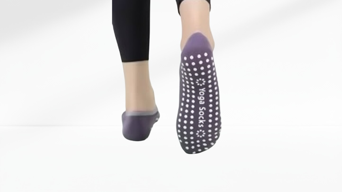 Purple grip socks ballet with white dots worn by a person on a white background