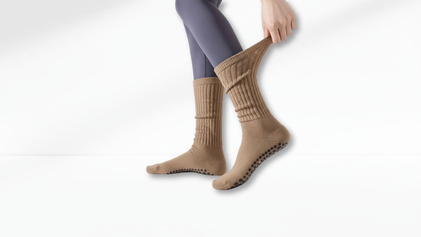 Beige grip socks worn with gray leggings on a white background
