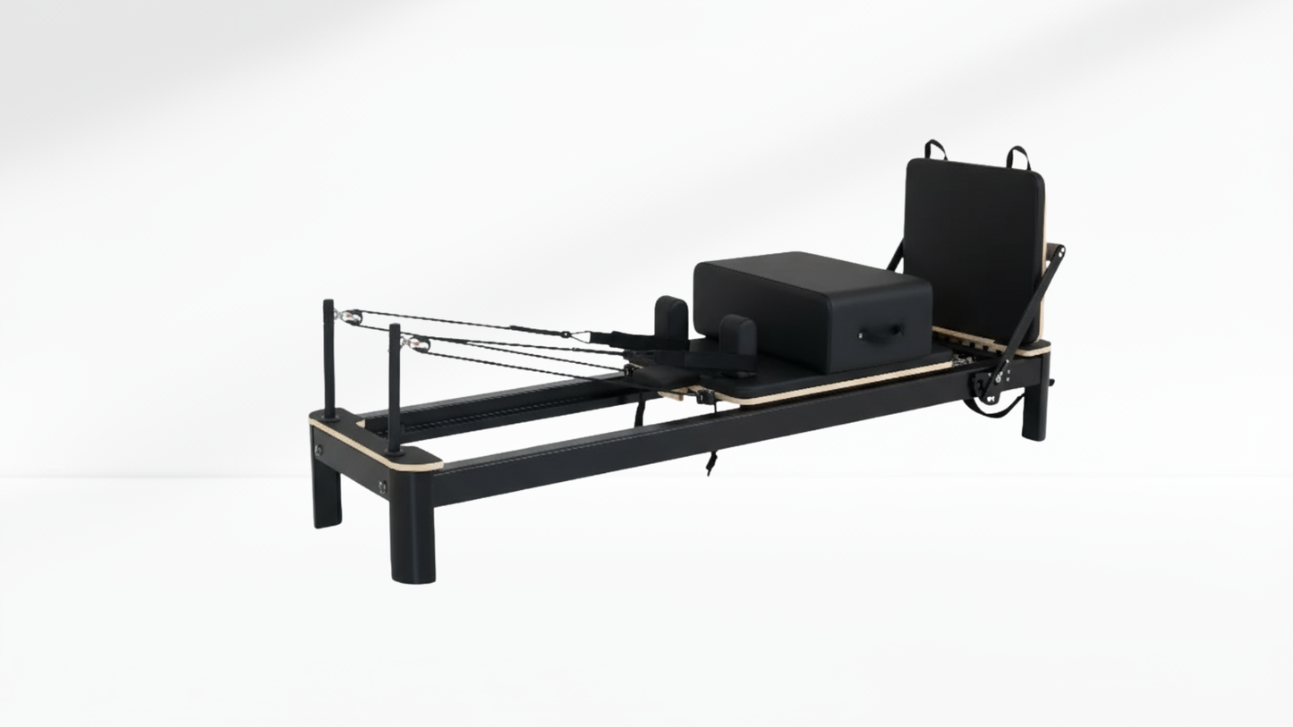 Black Pilates reformer on a white background