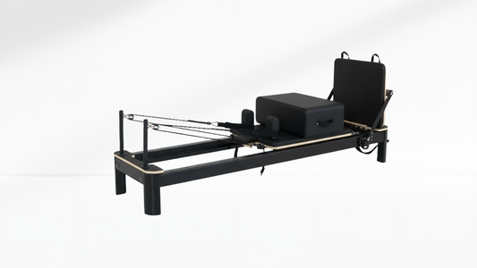 Black Pilates reformer on a white background