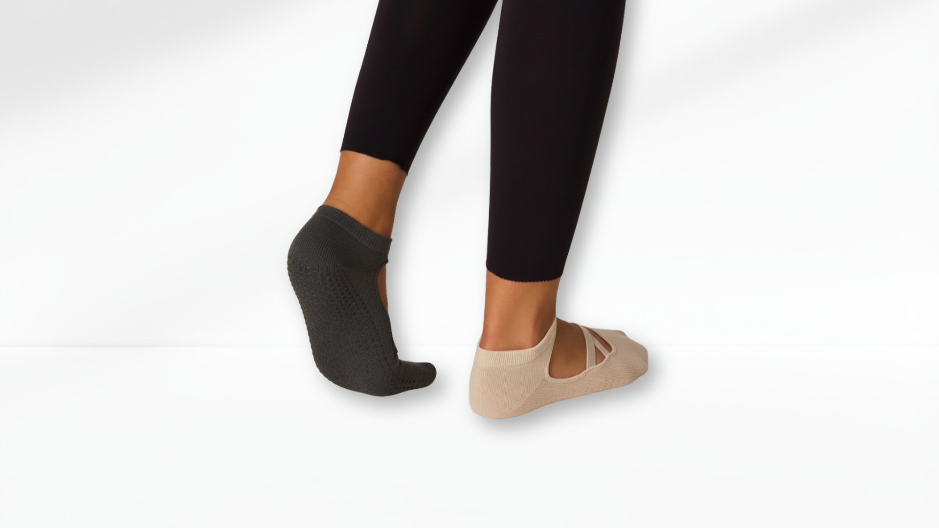 Black and beige grip sock worn with black leggings on a white background