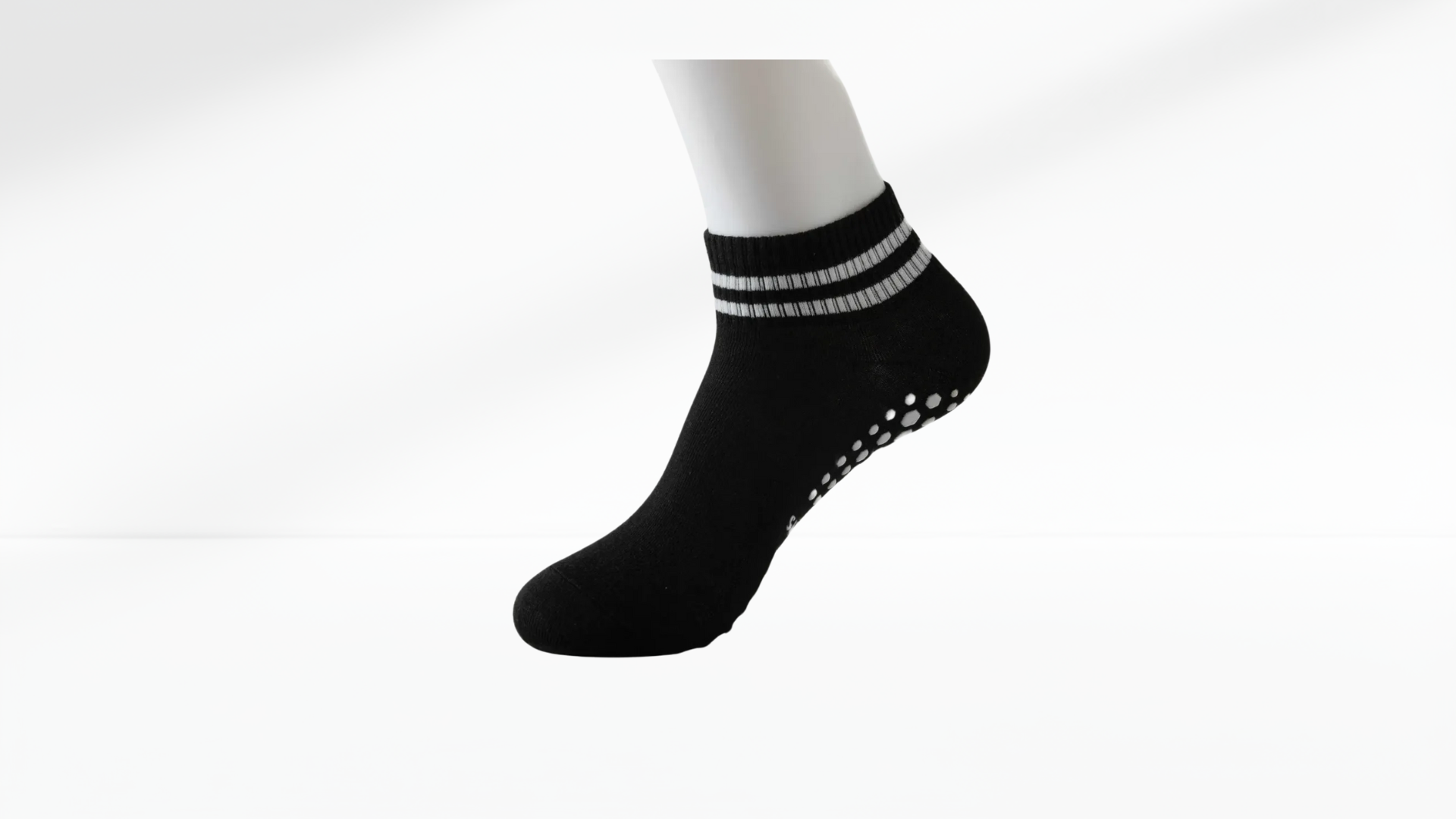 Black ankle grop sock with white stripes on a white background