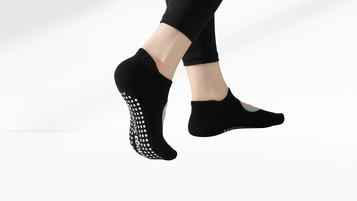 Black grip socks with white patterns worn by a person on a white background