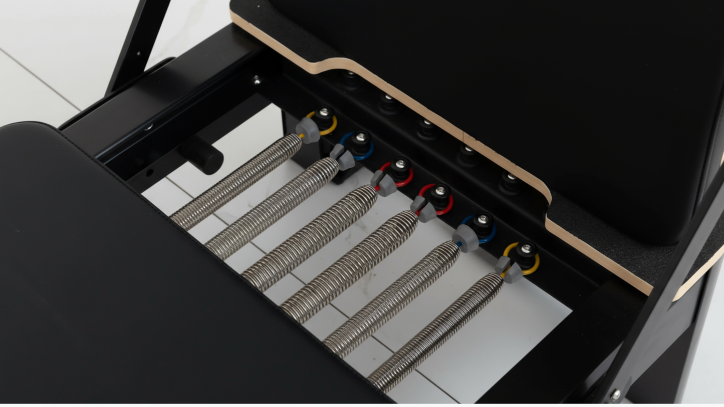Close-up of a Pilates Reformer mechanical device with springs and gears on a white background