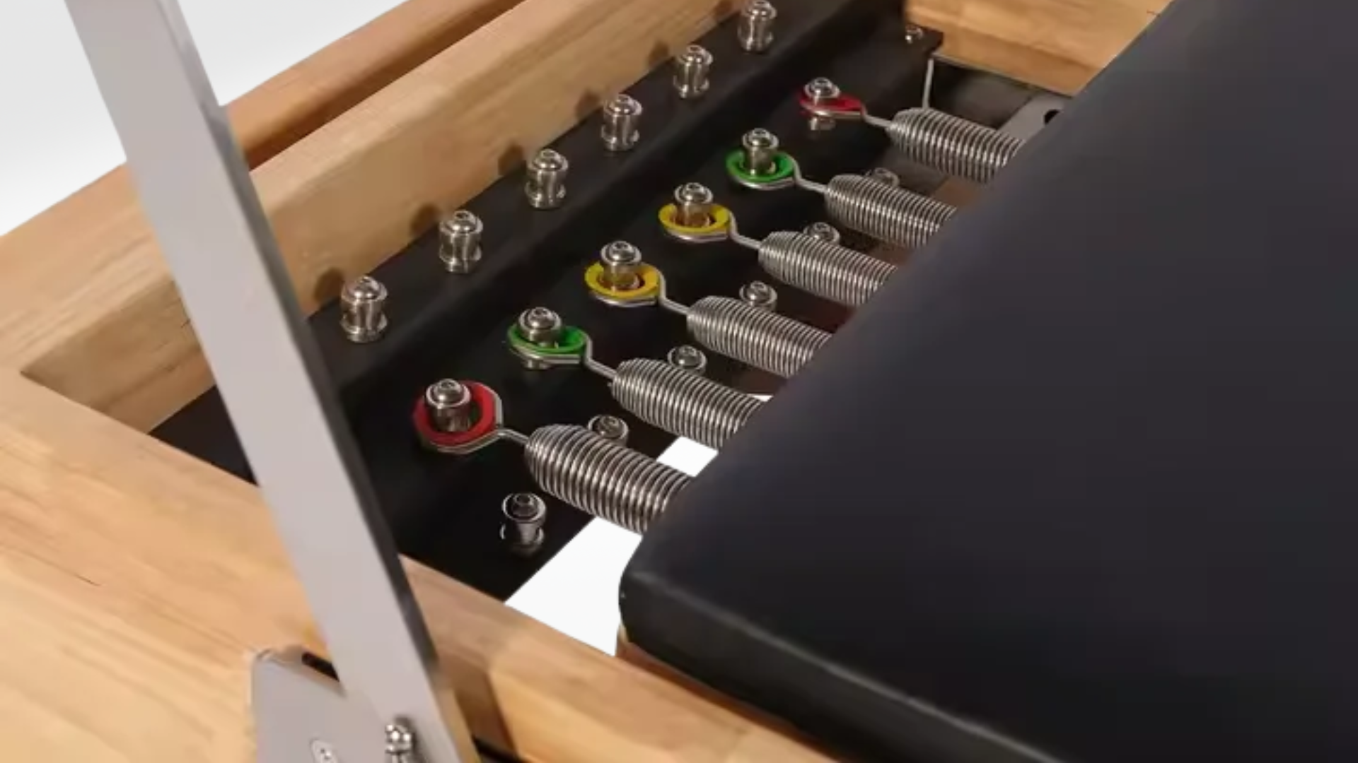 Close-up of a mechanical device with springs and metal components on a wooden surface.