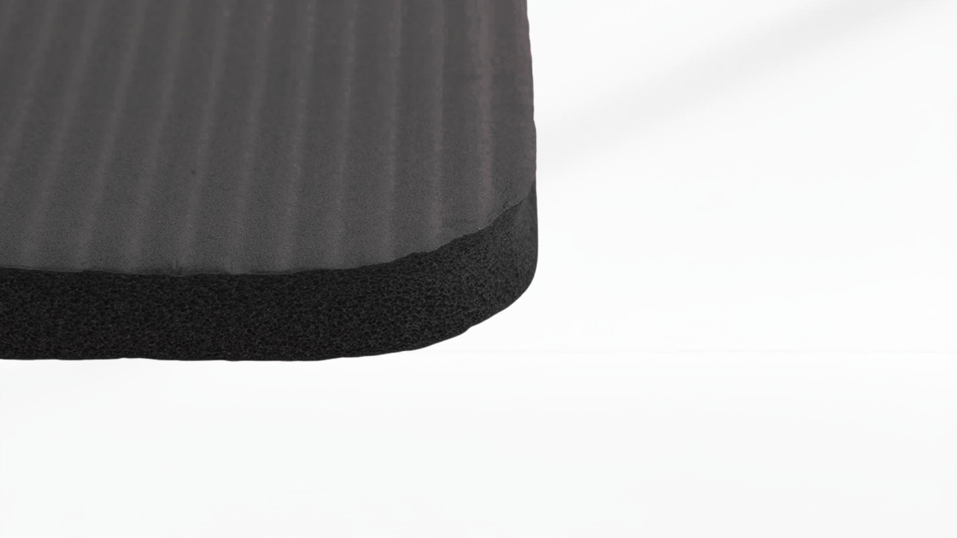 Close-up of a textured black mat corner on a white background