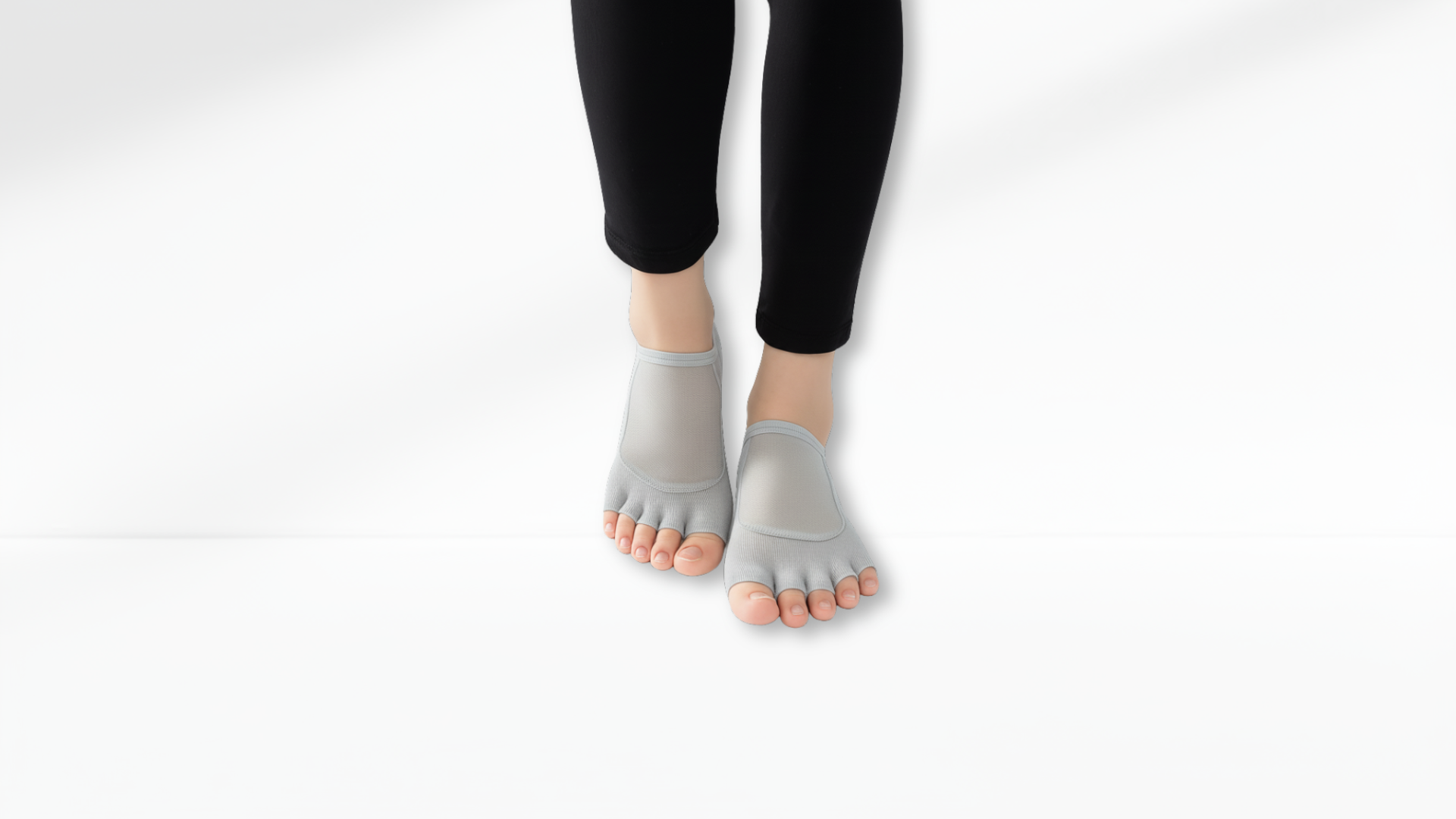 Gray Toe Socks Mesh Grip worn with black leggings on a white background