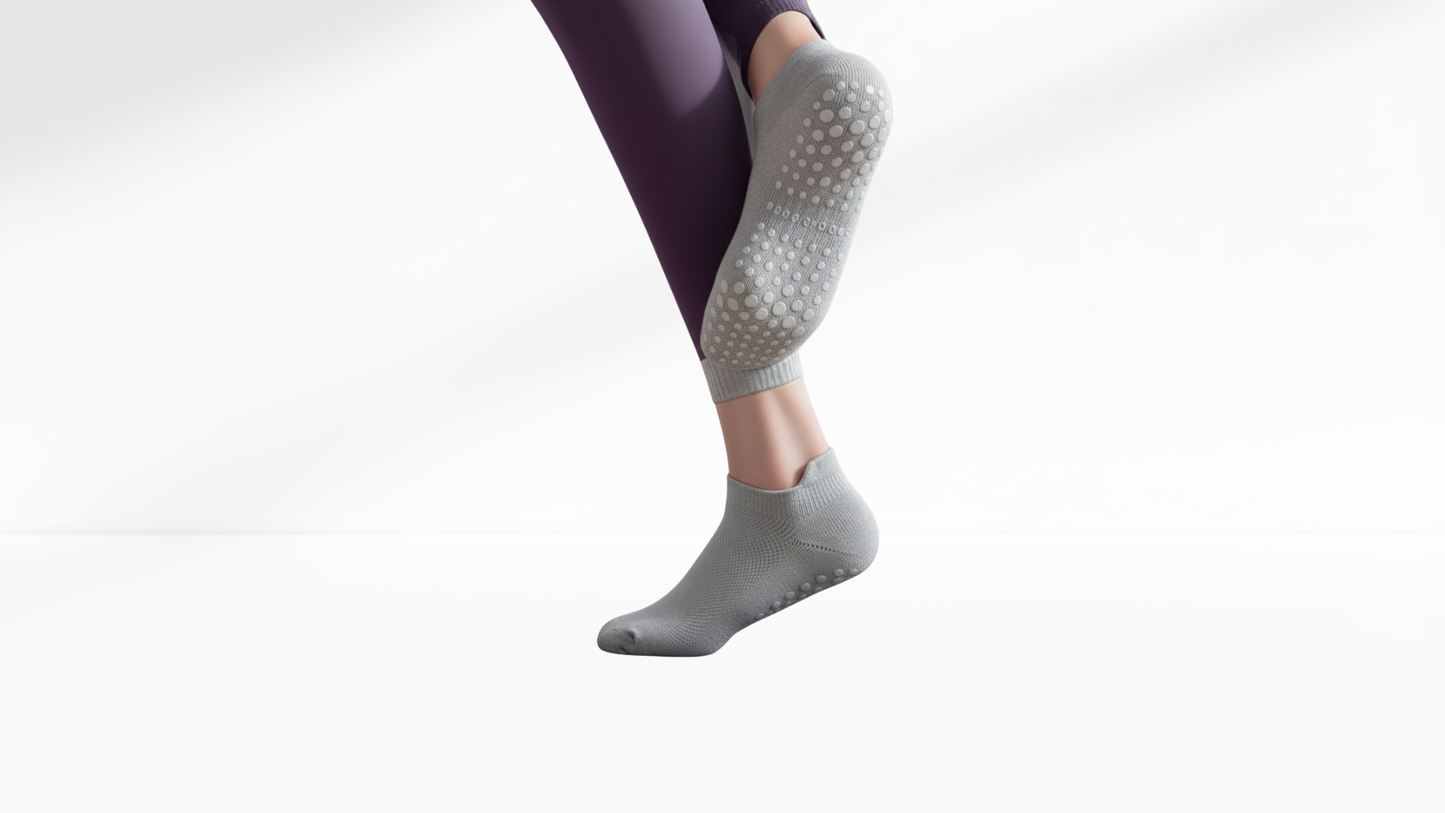 Gray grip socks with textured sole worn by a person on a white background