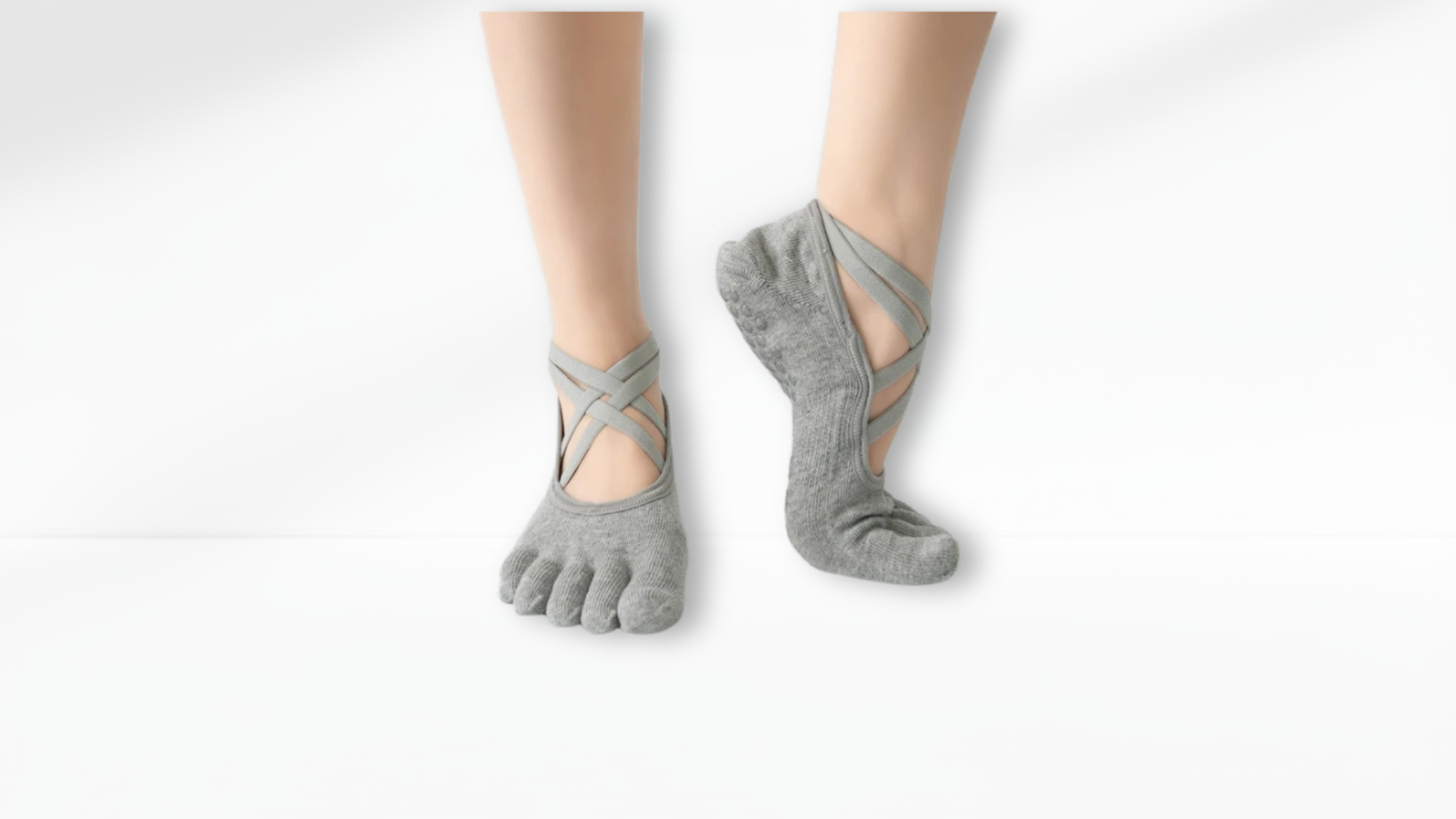 Gray toe-separated socks worn on a white background