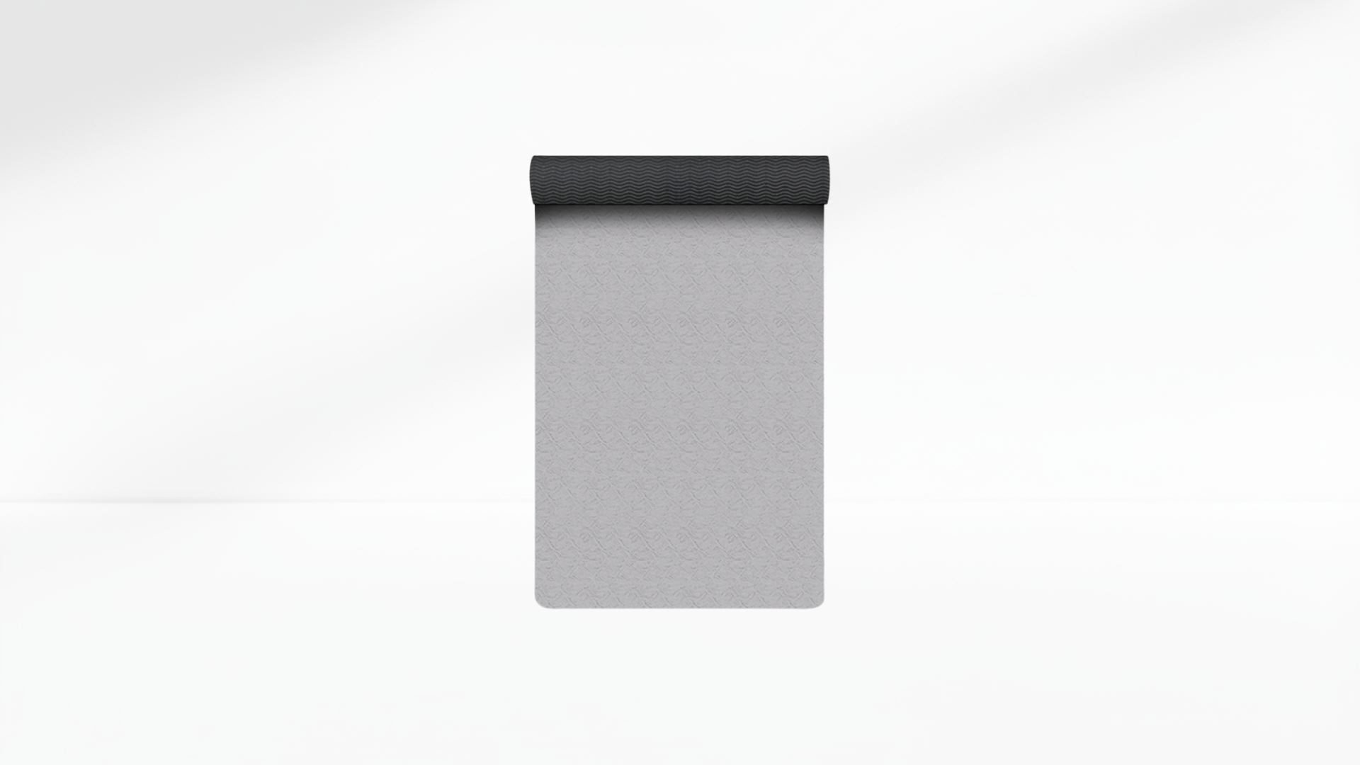 Gray yoga mat with black top on a white background