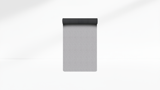 Gray yoga mat with black top on a white background
