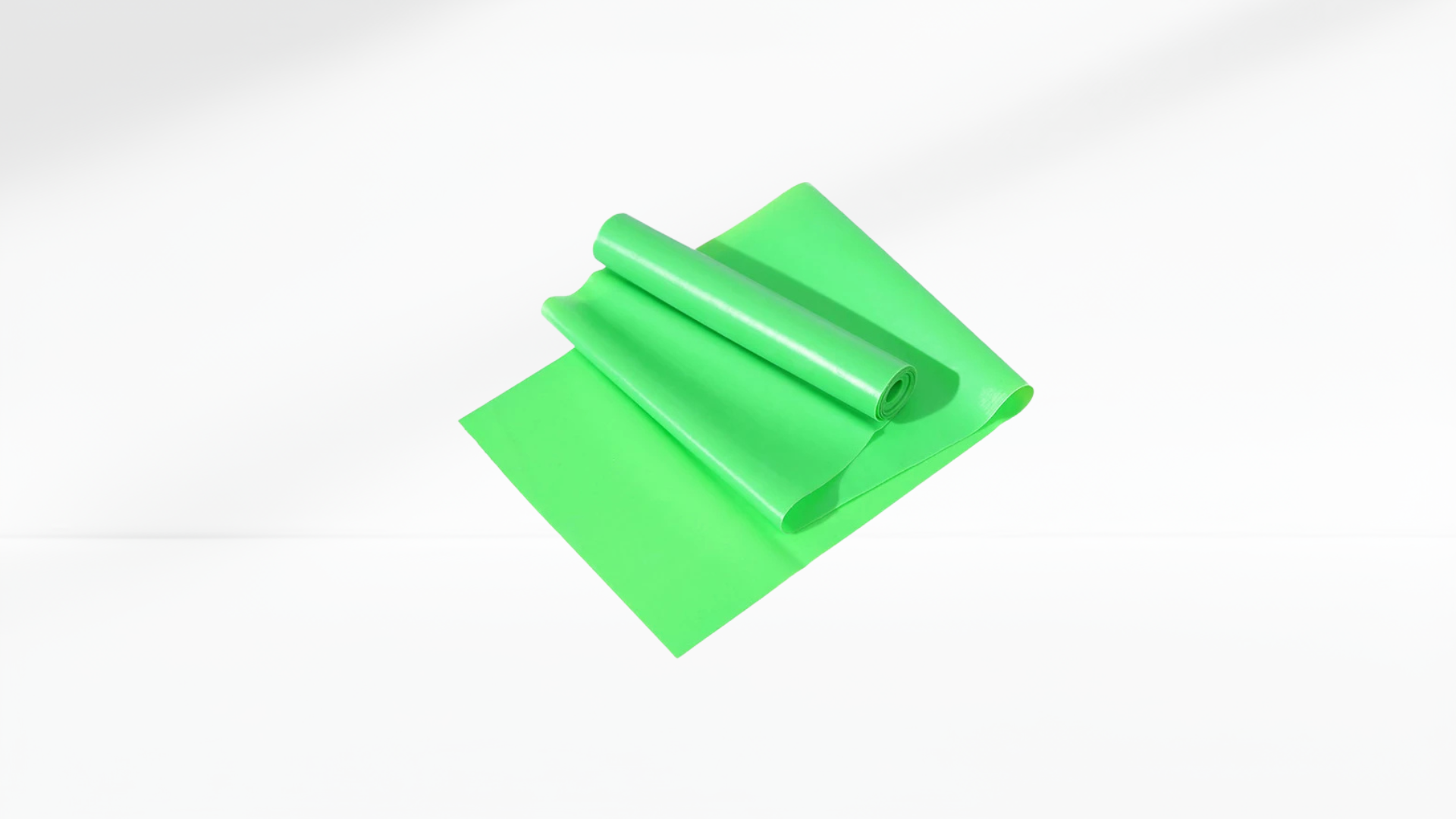 Green Yoga & Pilates Elastic Resistance Band roll on a white background