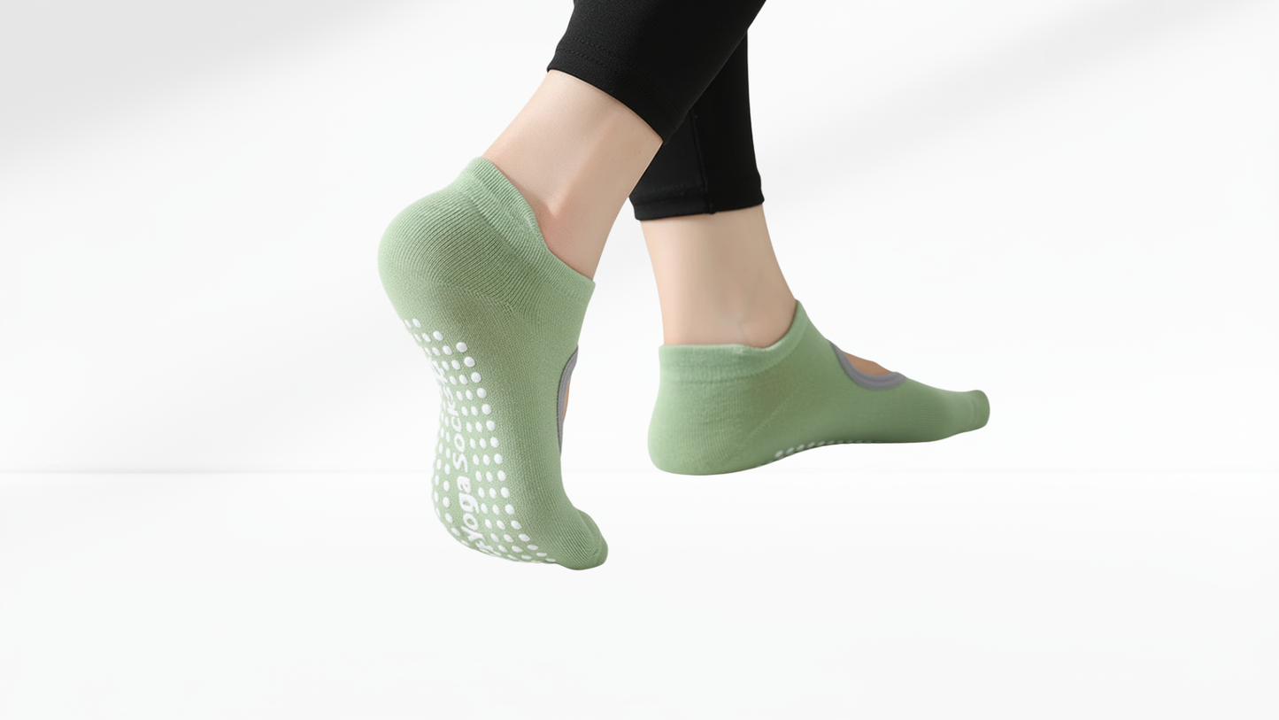 Green non-slip grip socks worn by a person on a white background