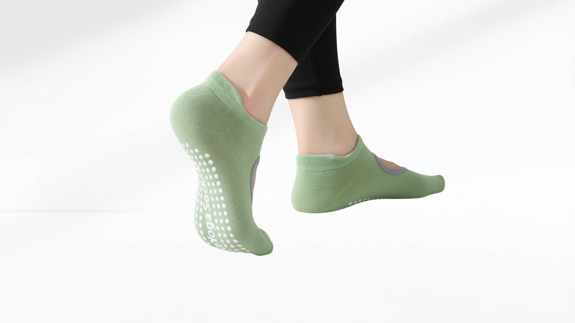 Green non-slip grip socks worn by a person on a white background