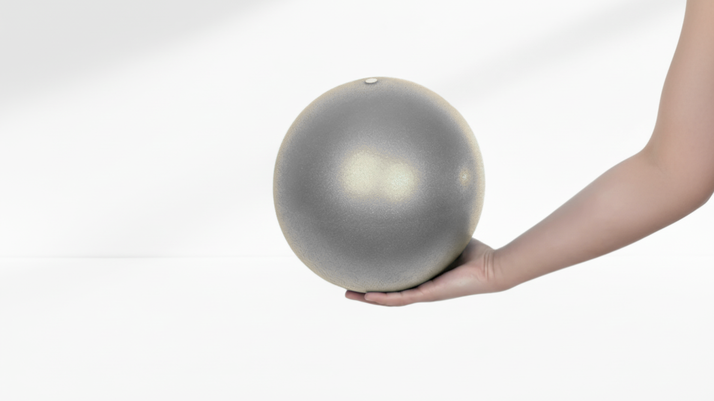 Hand holding a grey ball against a white background