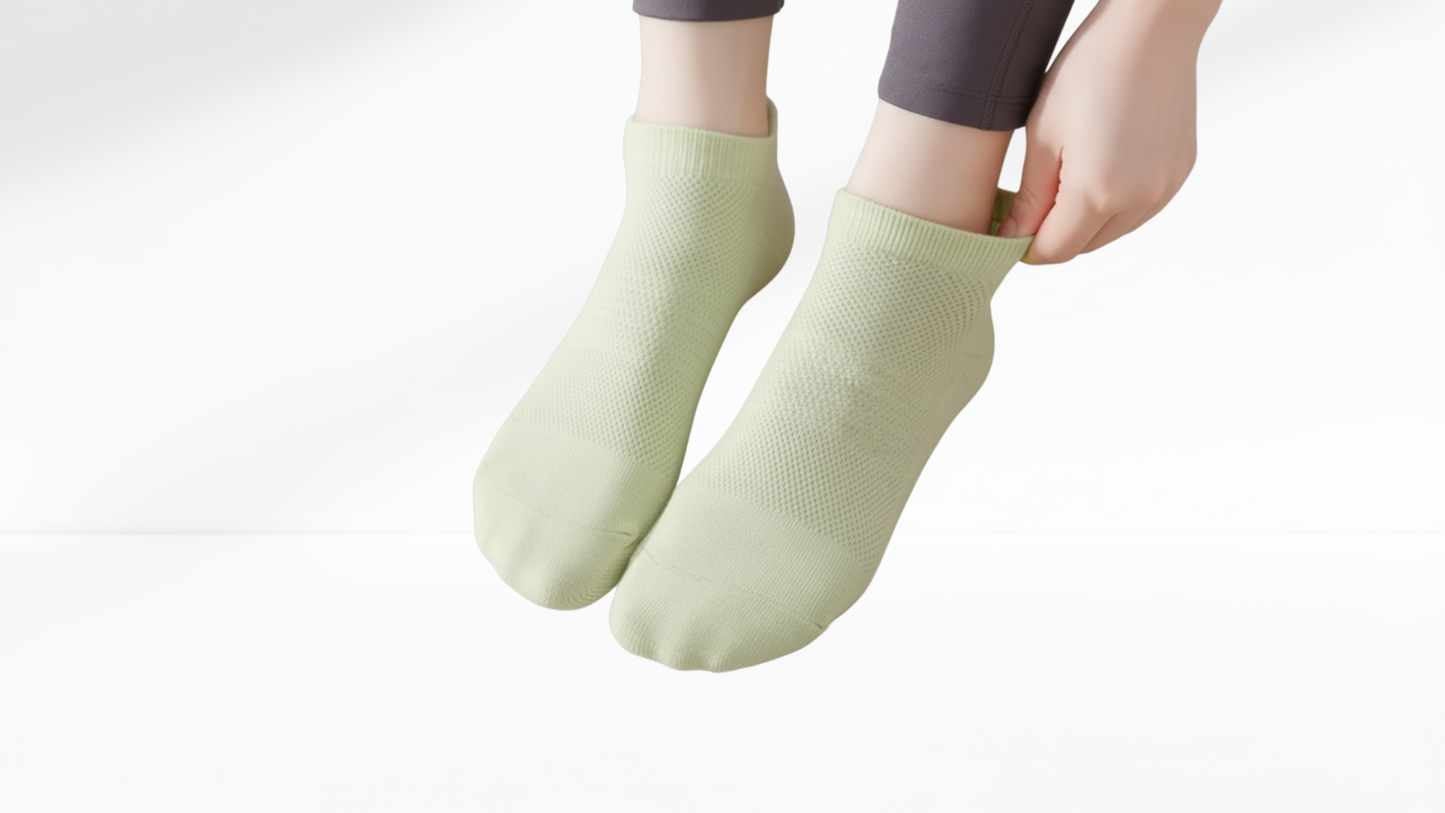 Light green grip socks worn by a person on a white background