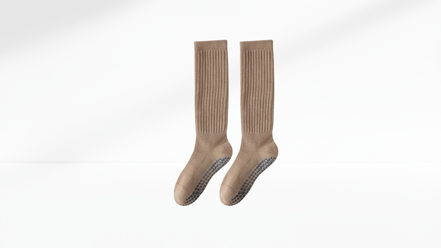 Pair of beige grip socks on a white background