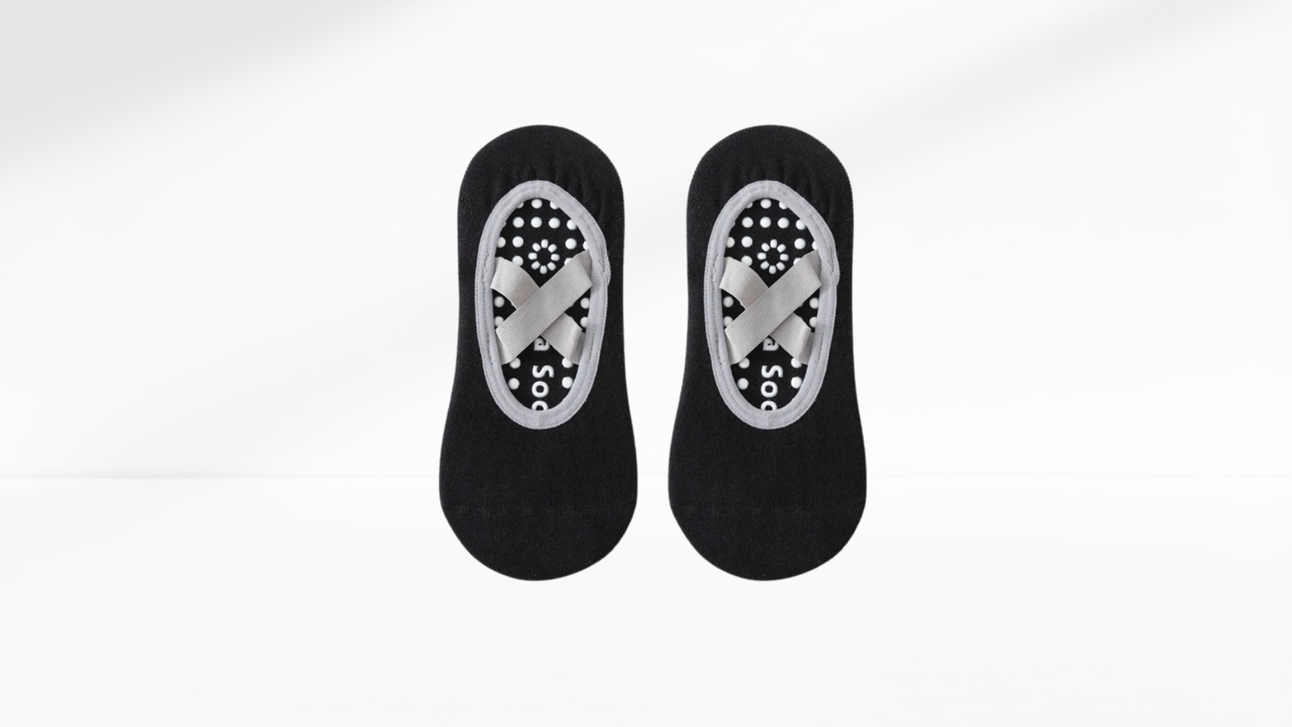 Pair of black grip socks ballet with patterned sole on a white background