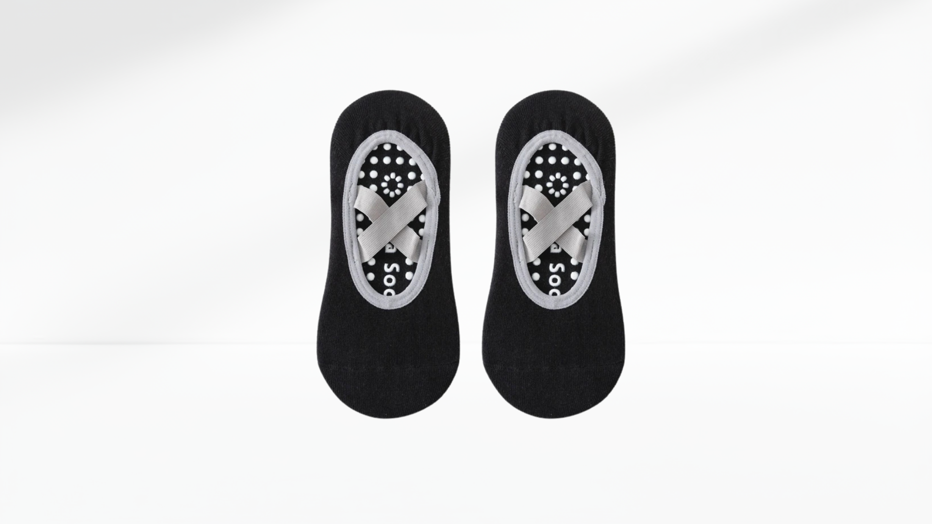 Pair of black grip socks ballet with patterned sole on a white background