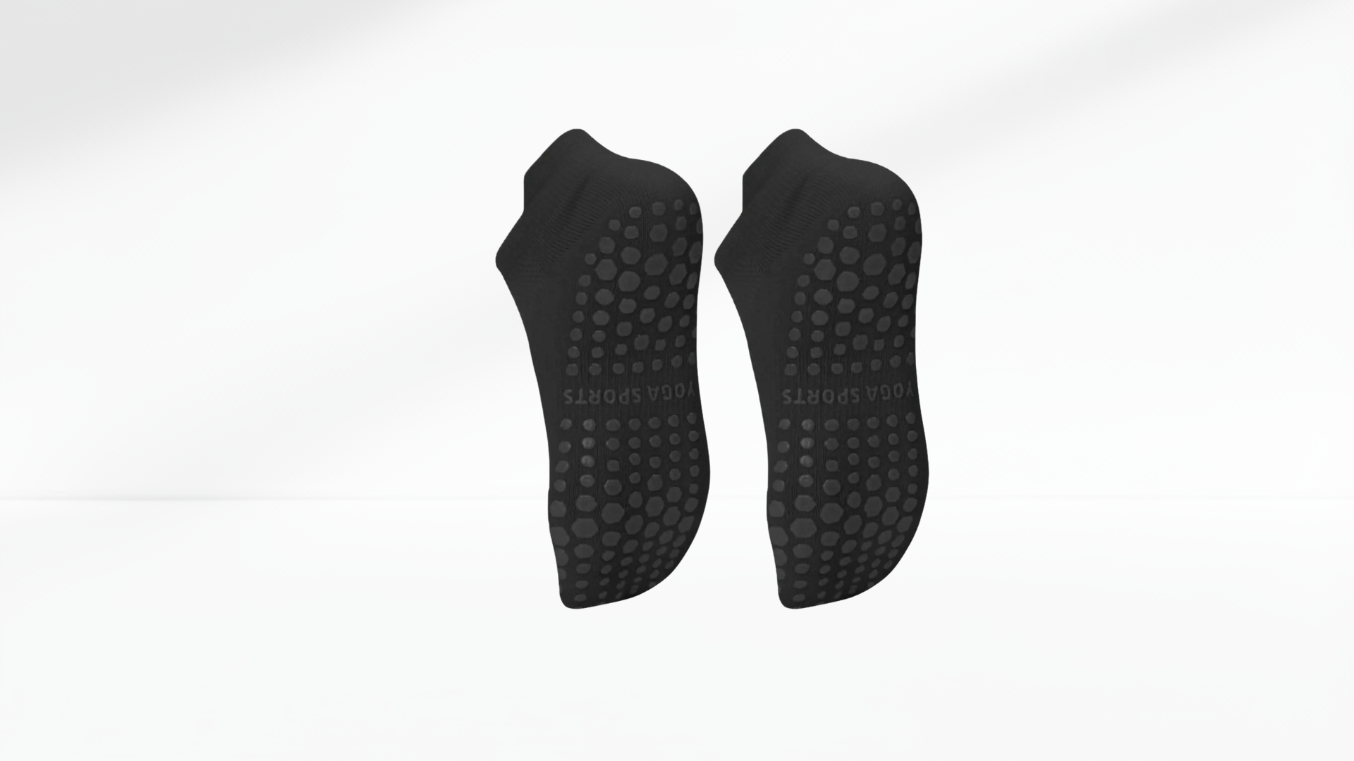 Pair of black grip socks with textured sole on a white background