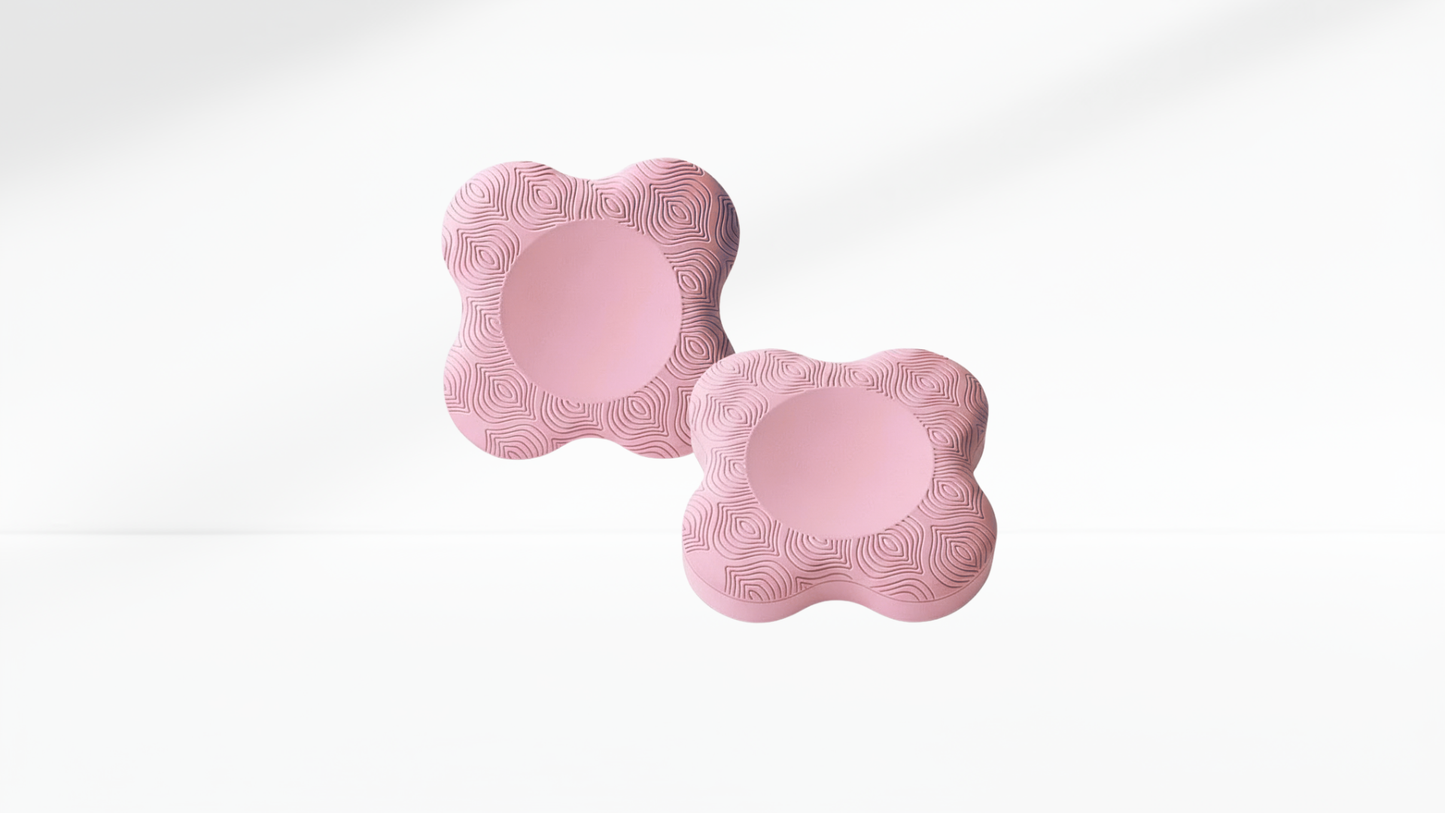 Pair of light-pink ergonomic elbow pads with textured surface, displayed on a clean white background.