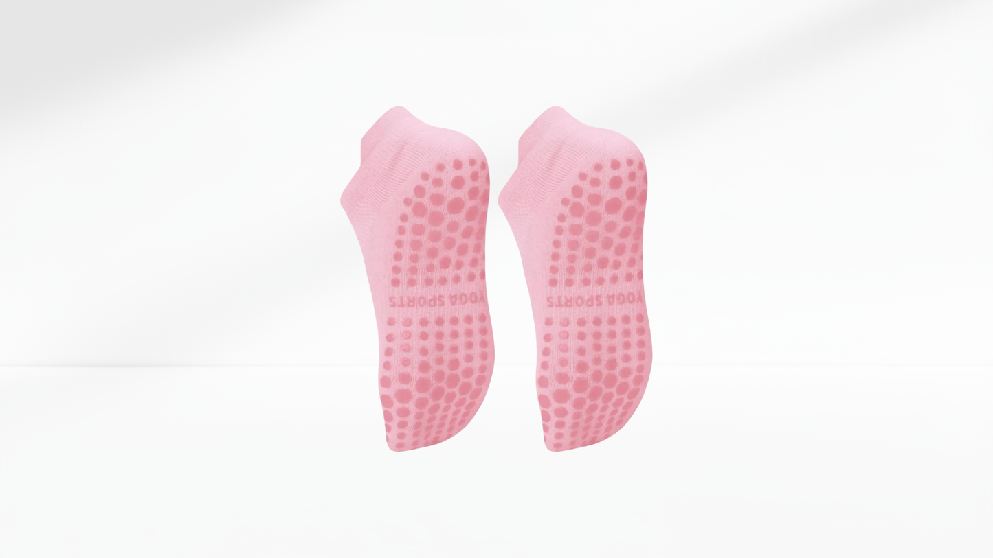 Pair of pink grip socks with textured sole on a white background