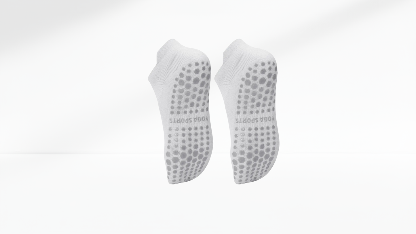 Pair of white grip socks with textured sole on a white background