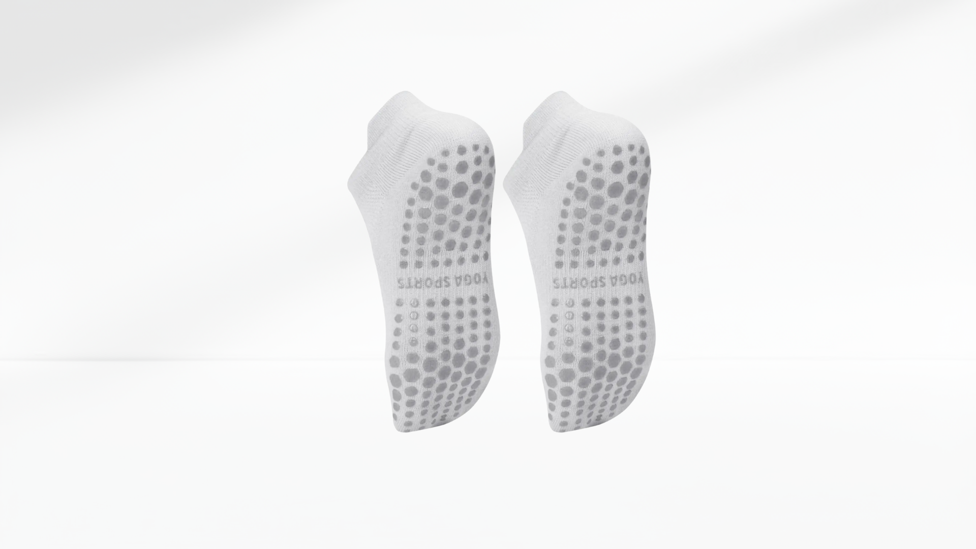 Pair of white grip socks with textured sole on a white background