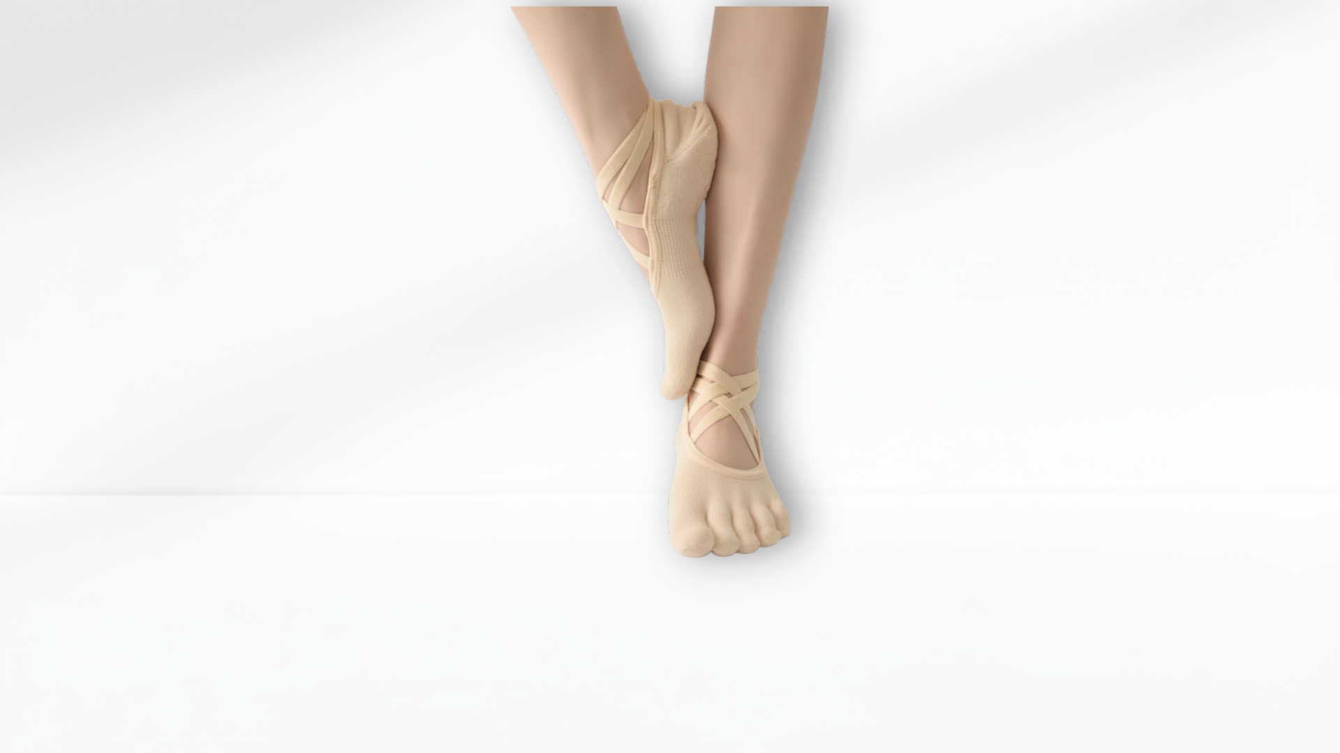 Person wearing beige toe-separated socks on a white background