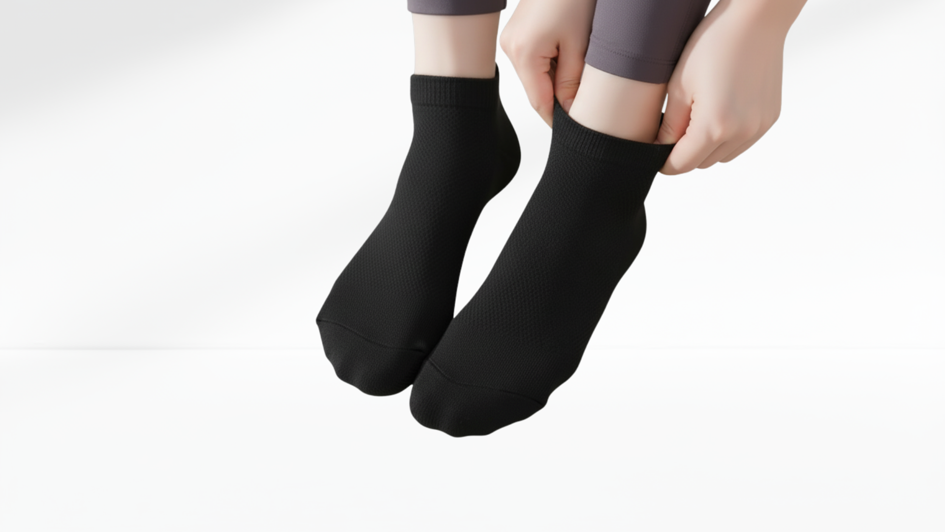 Person wearing black grip socks on a white background