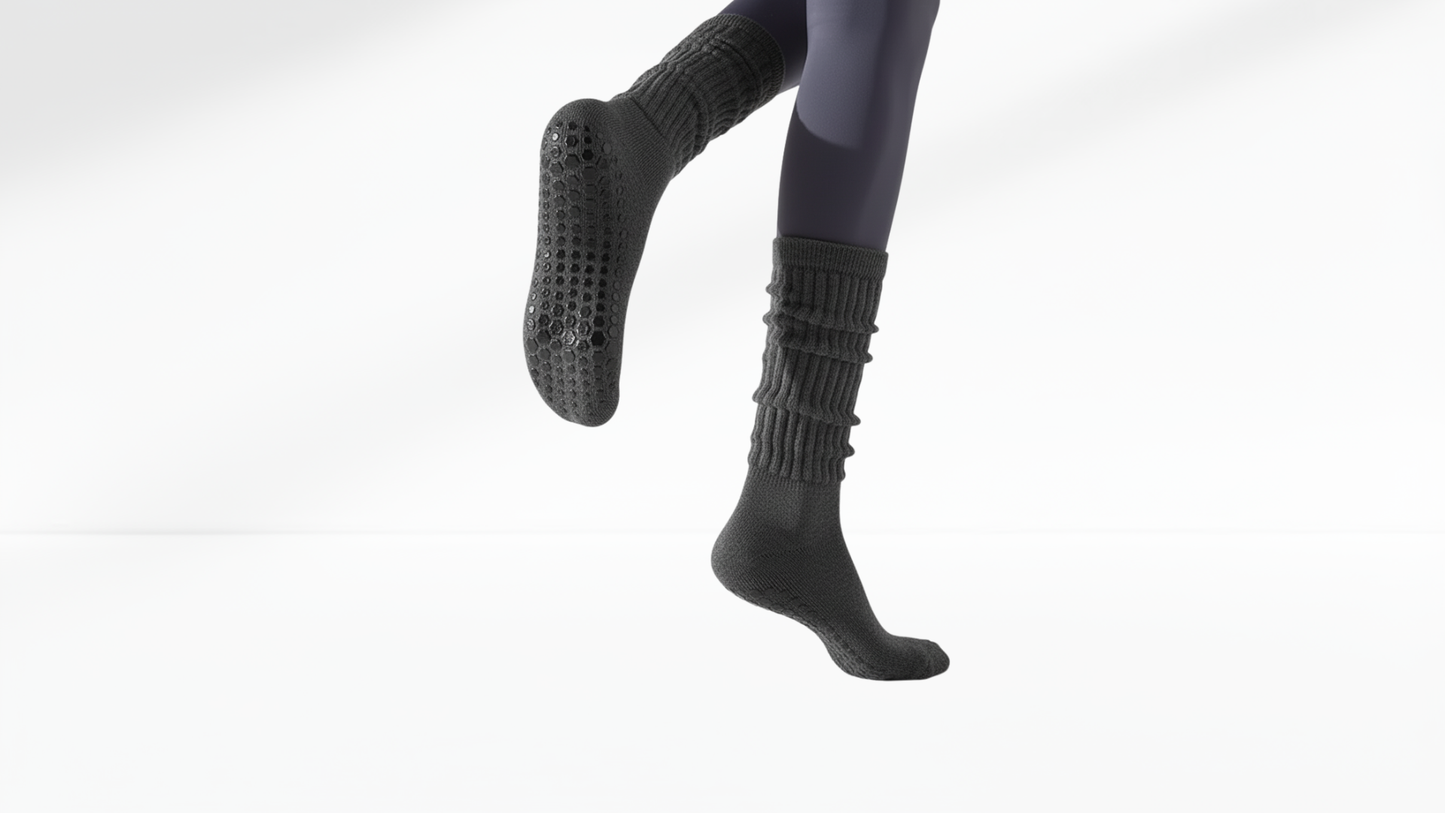 Person wearing grey  textured grip socks on a white background