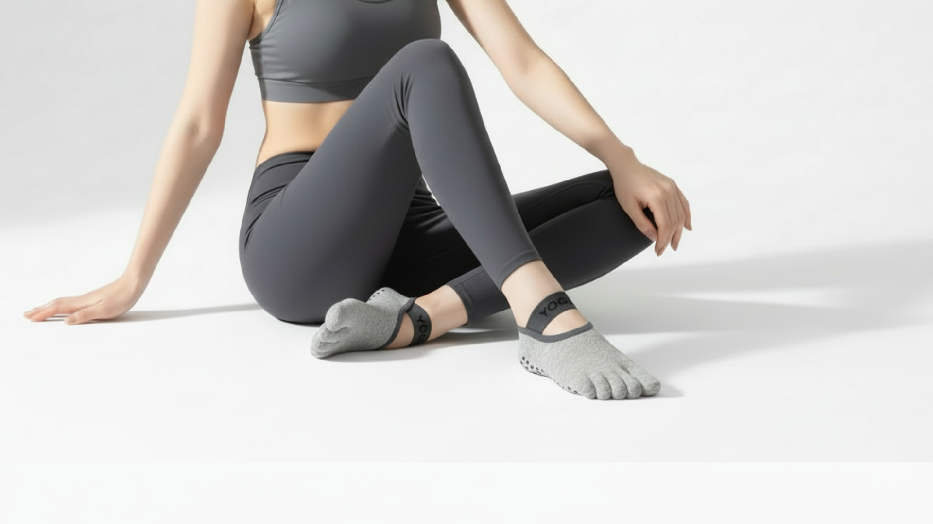 Person wearing gray athletic leggings and a Toe Socks – Strap Edition on a light gray background