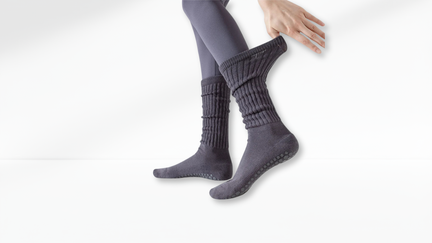 Person wearing gray grip socks on a white background