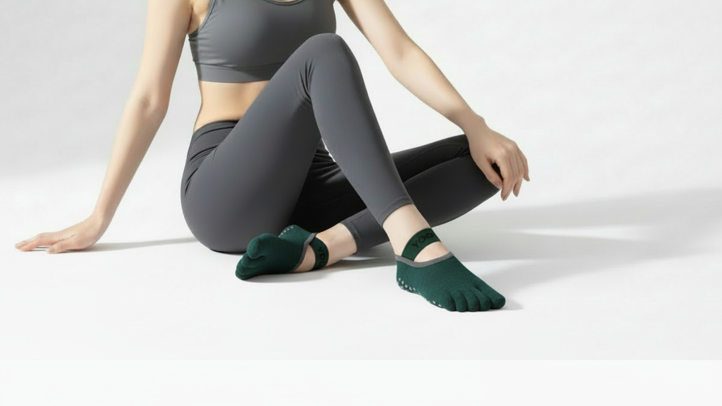 Person wearing green yoga Toe Socks – Strap Edition sitting on a white background