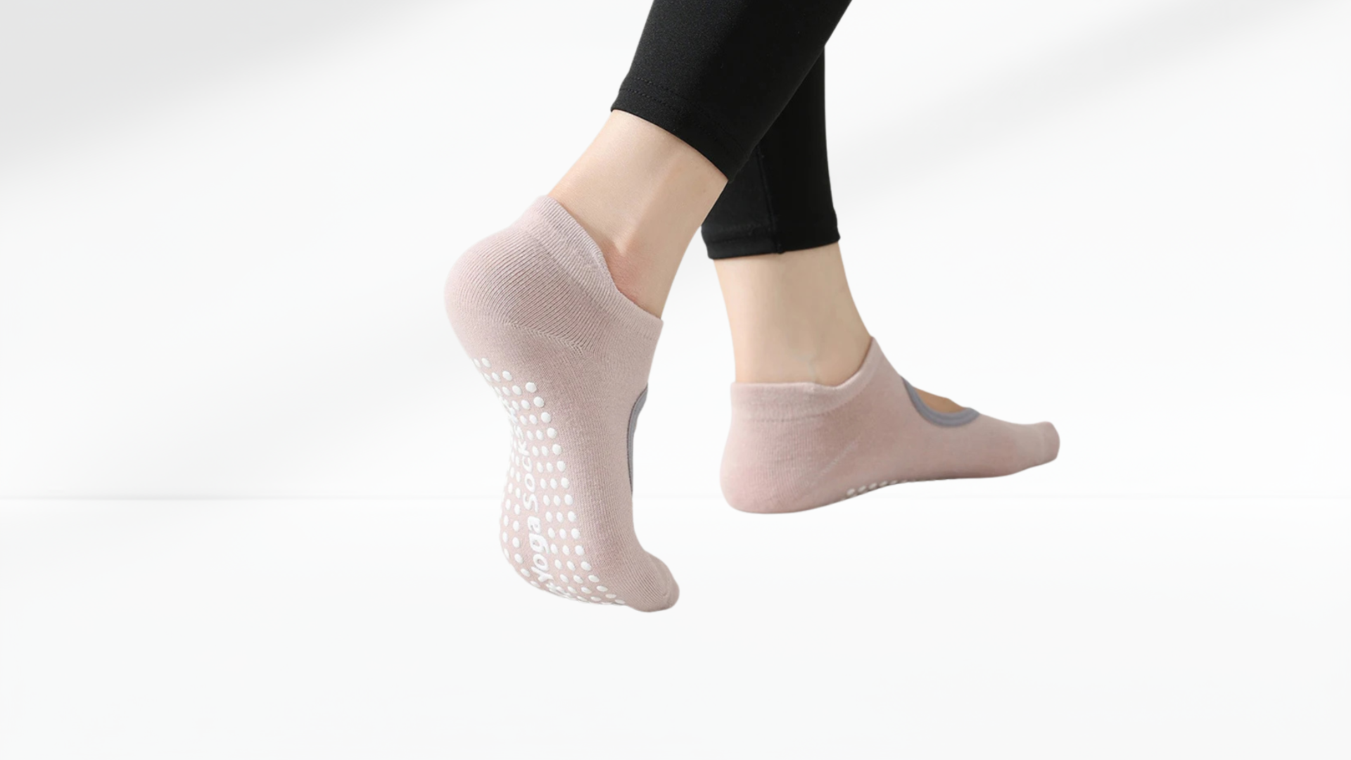 Person wearing light pink ankle grip socks with grip dots on a white background