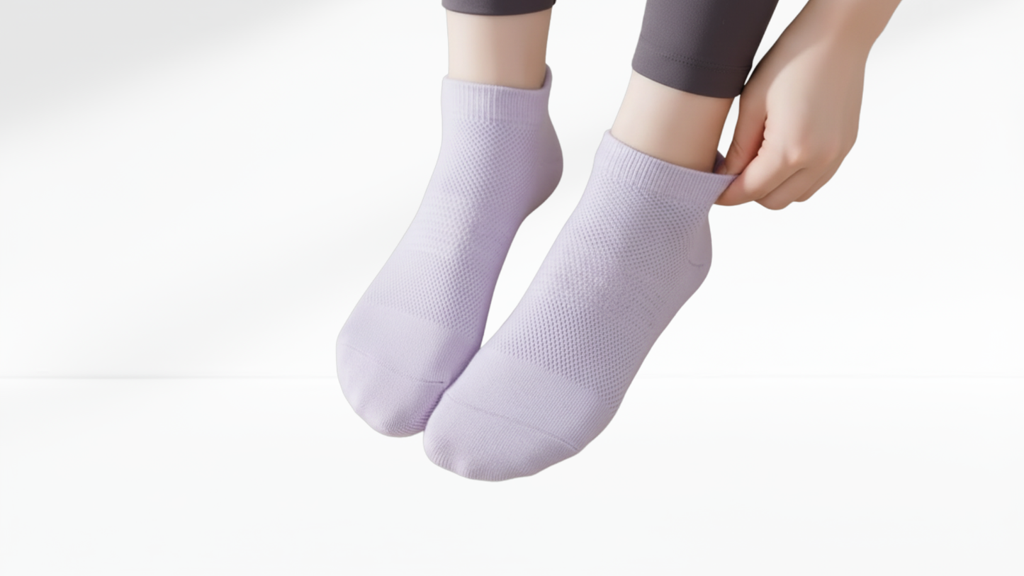 Person wearing light purple grip socks on a white background