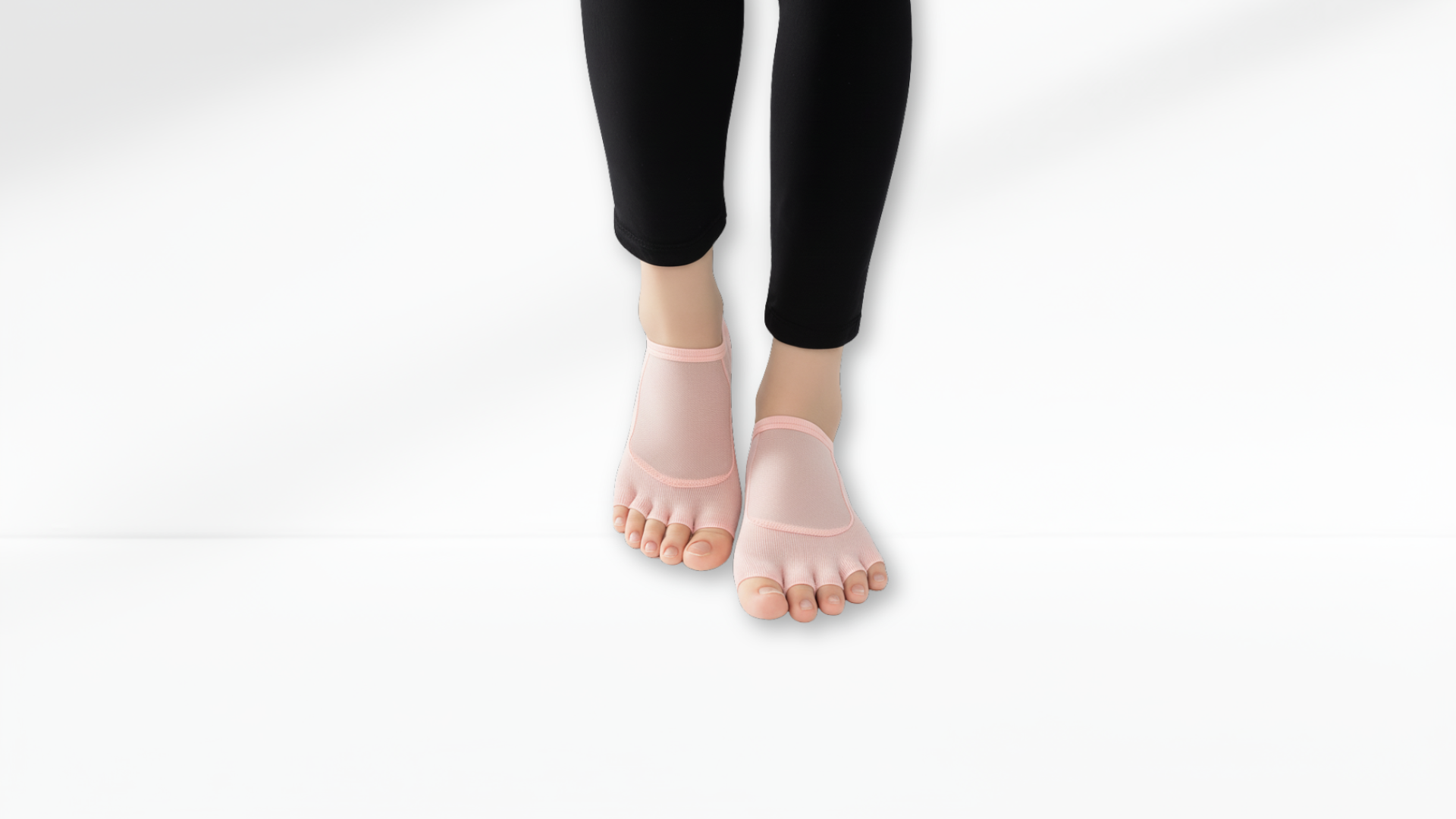 Person wearing pink Toe Socks Mesh Grip with black leggings on a white background
