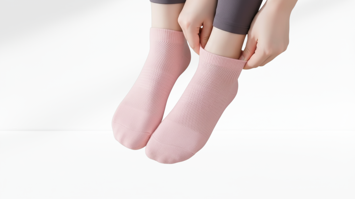 Person wearing pink grip socks on a plain background