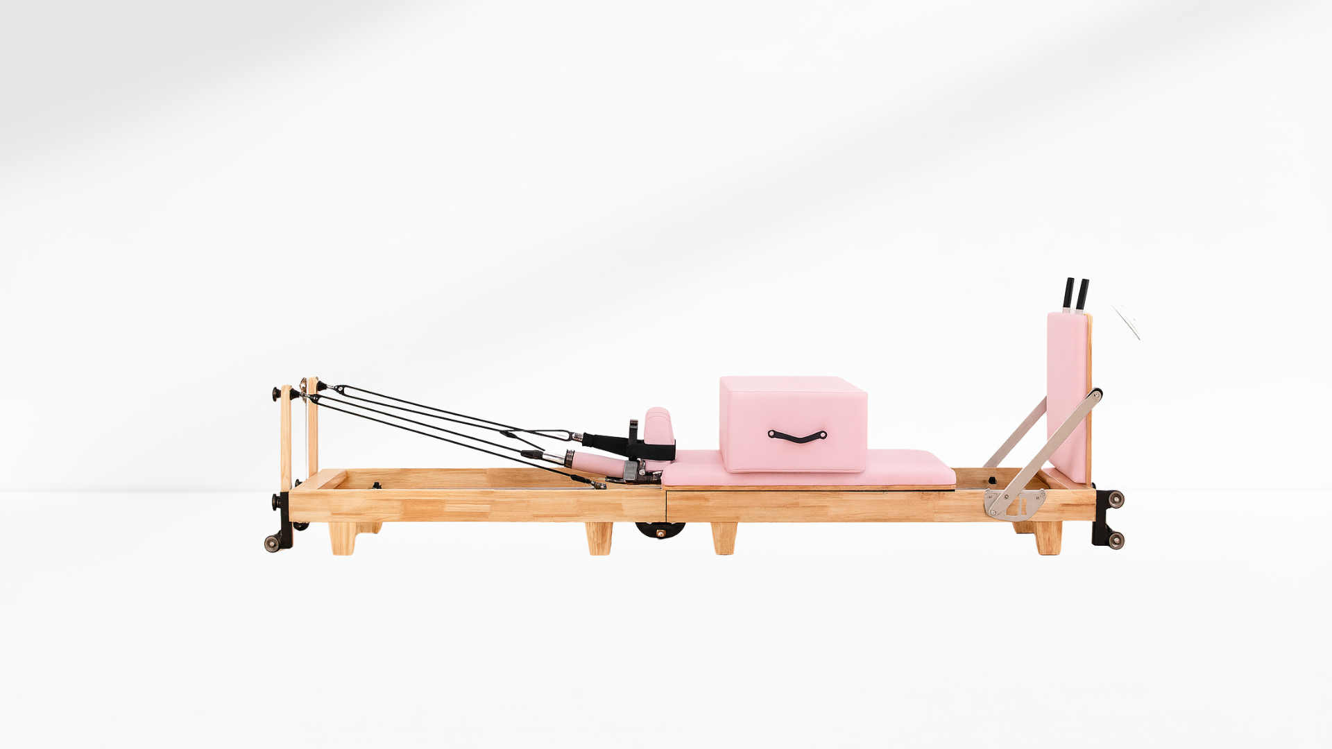 Pilates reformer with pink cushion on a white background