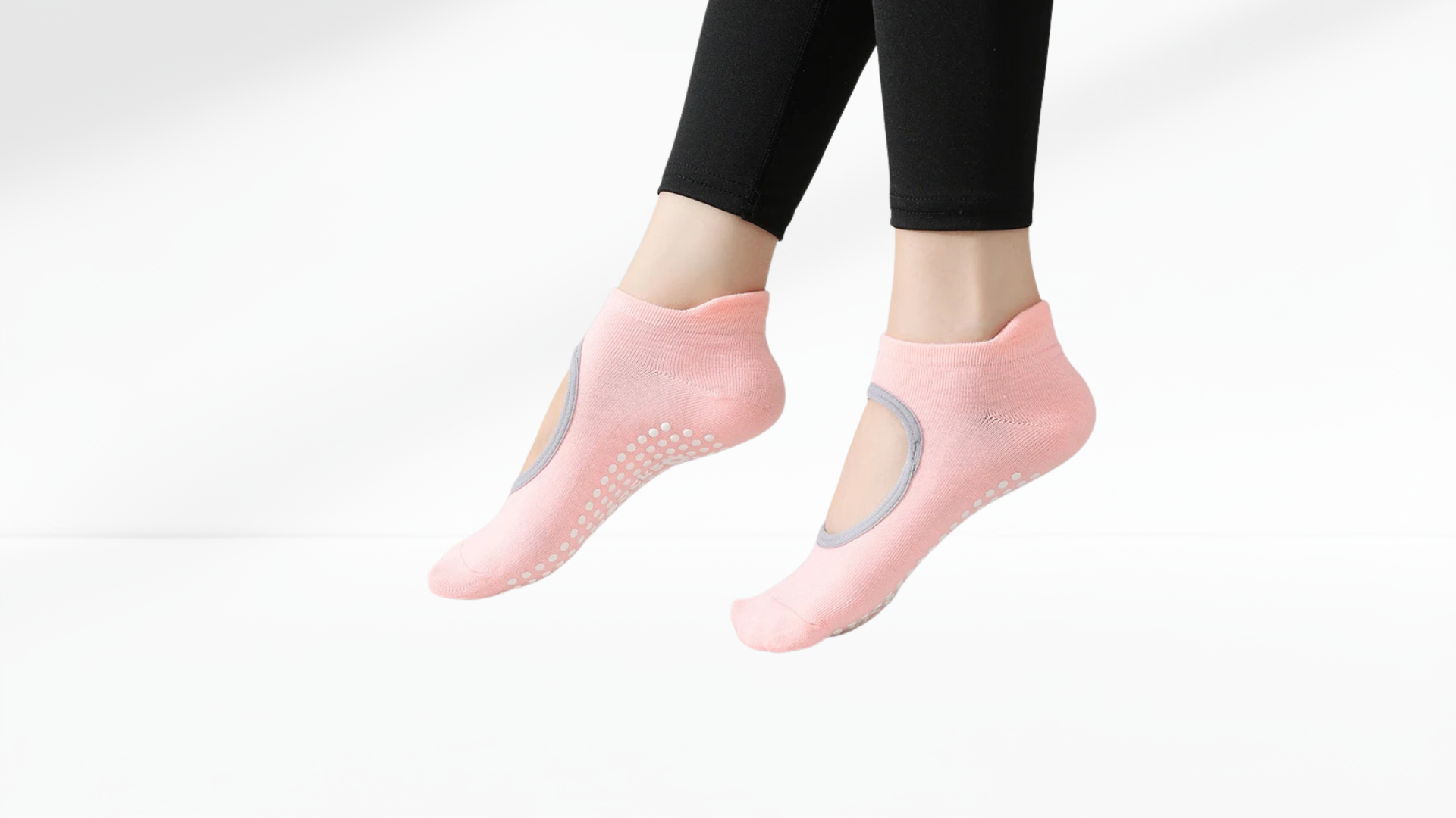 Pink grip socks with grip dots worn by a person on a white background