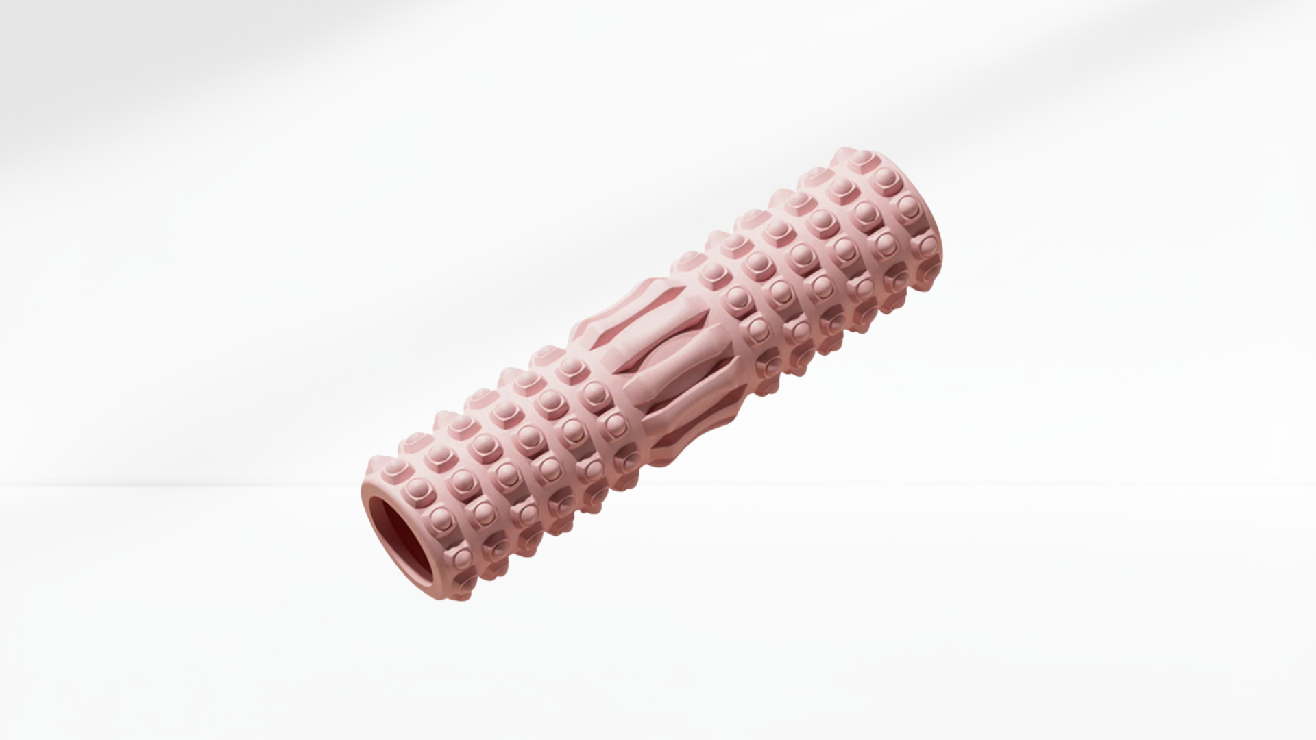 Pink textured foam roller on a white background