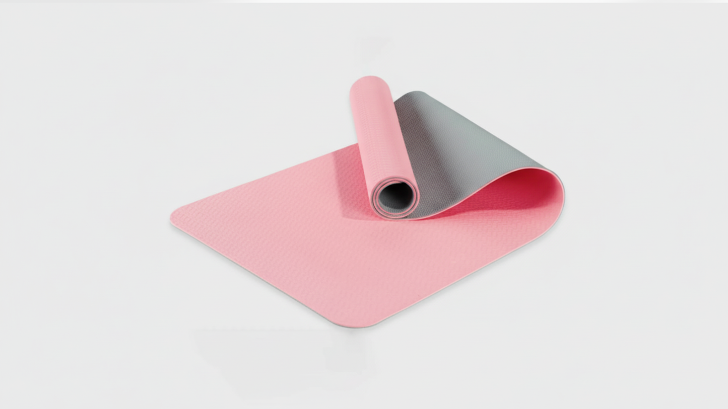 Pink yoga mat with gray interior on a light gray background