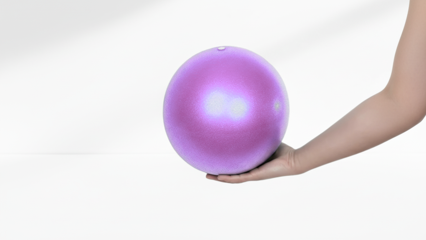 Purple exercise ball held by a hand on a white background