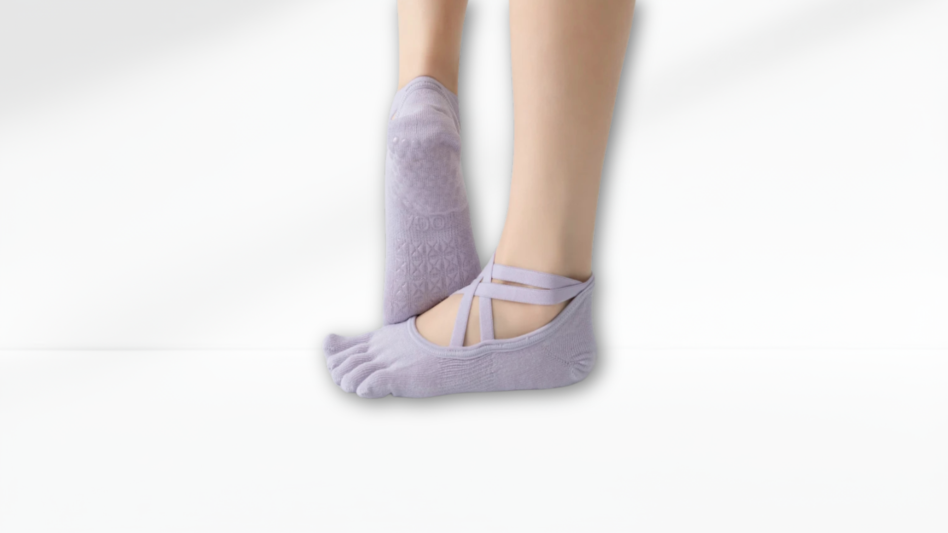 Purple toe socks worn with bare feet on a light gray background