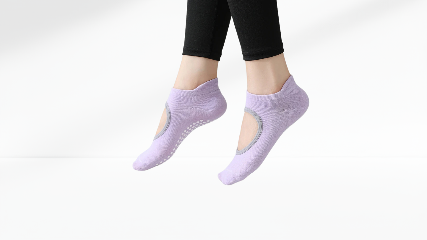 Purple yoga grip socks worn by a person on a white background