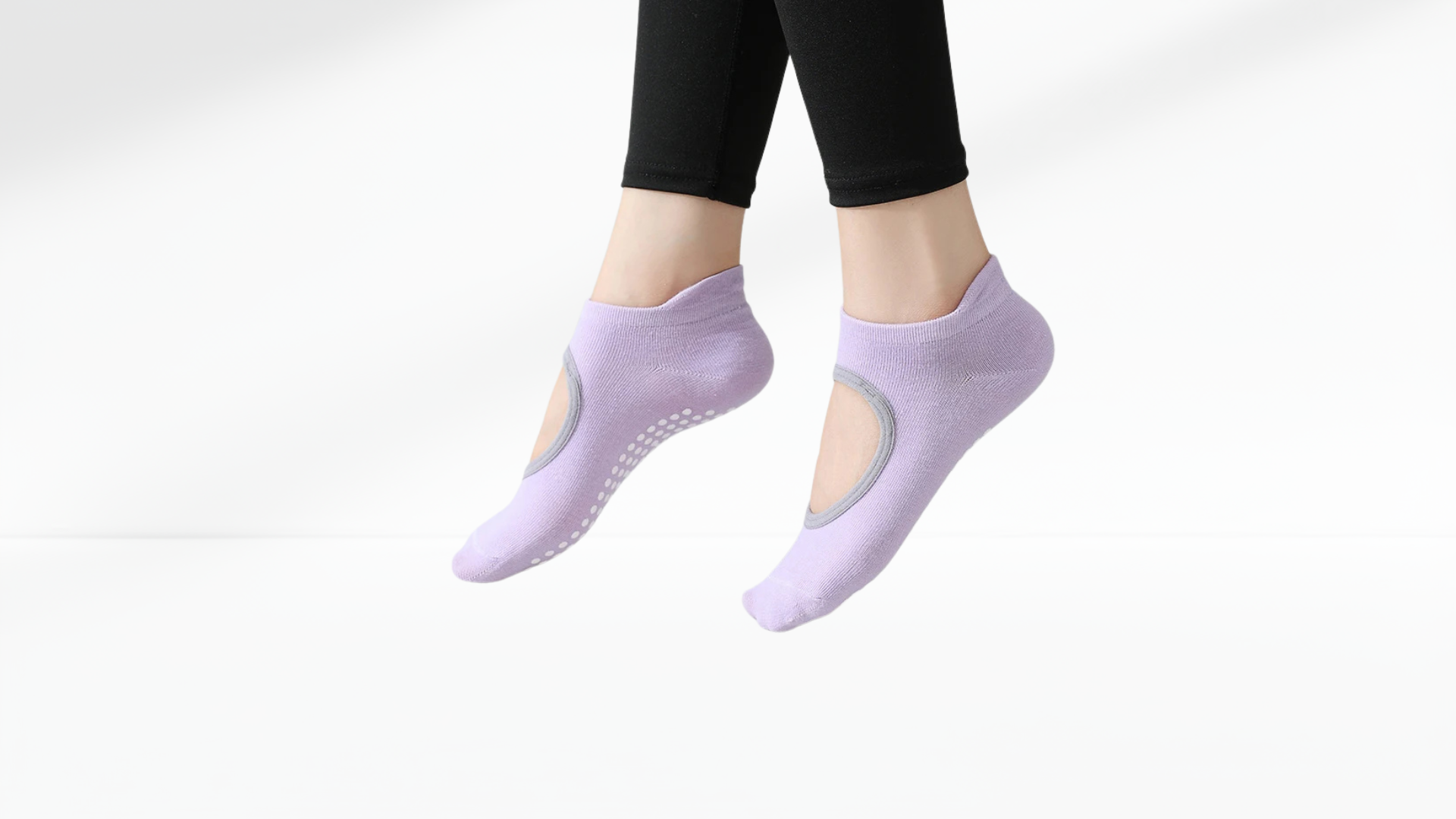 Purple yoga grip socks worn by a person on a white background