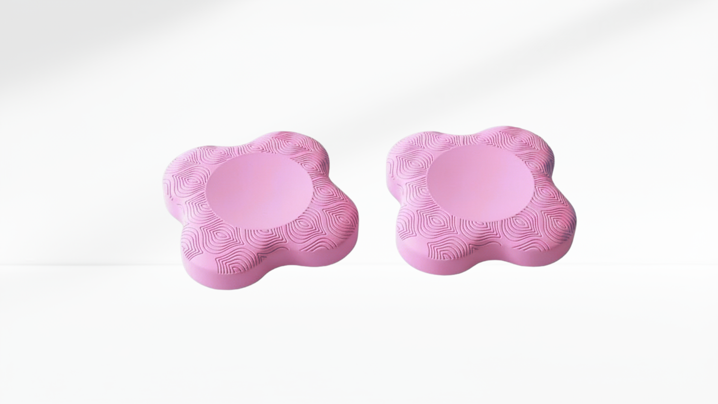 Two pink foam elbow support pads with curved ergonomic shape and swirl texture, shown on a white background.