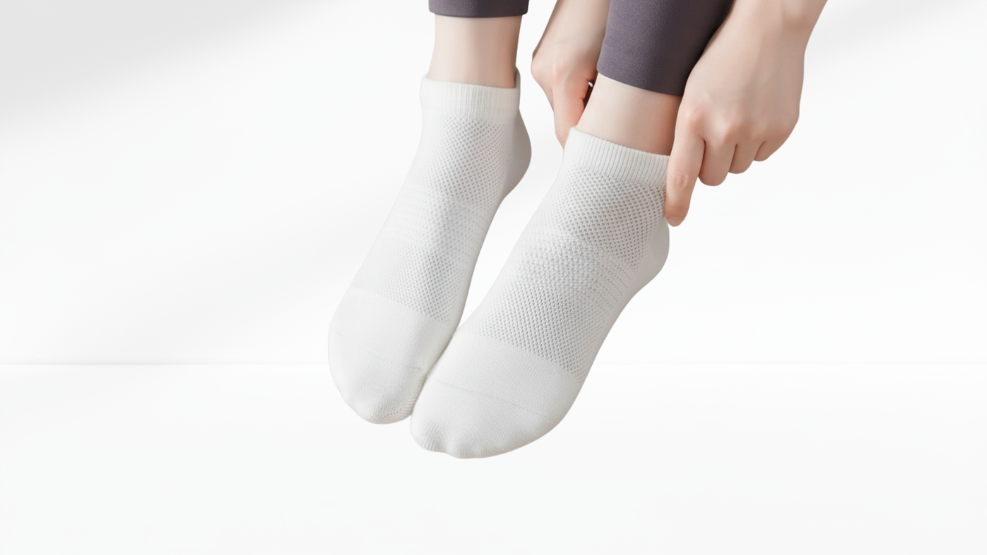 White grip socks being worn on a plain background