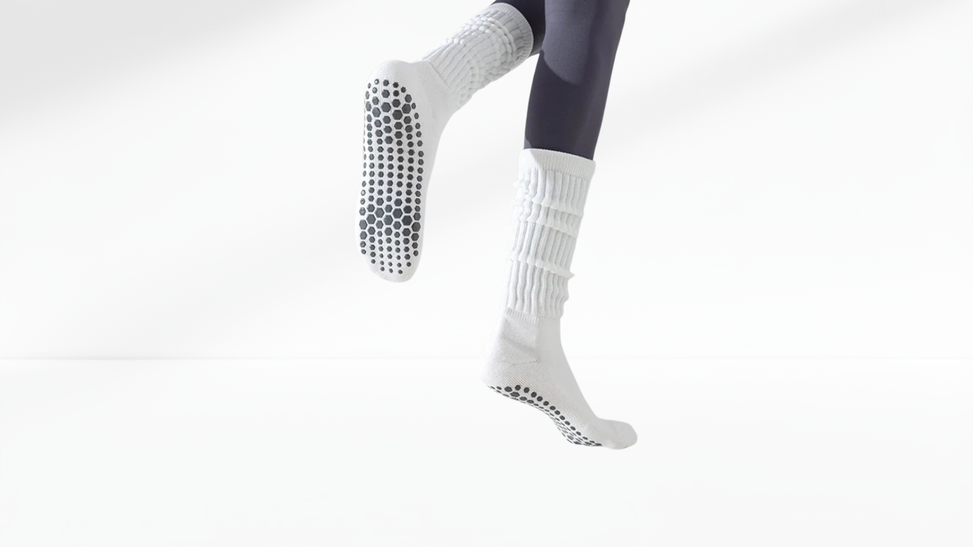 White grip socks with black textured sole on a white background